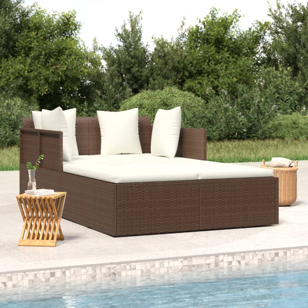 Brown woven garden sofa bed with cream cushions beside a pool